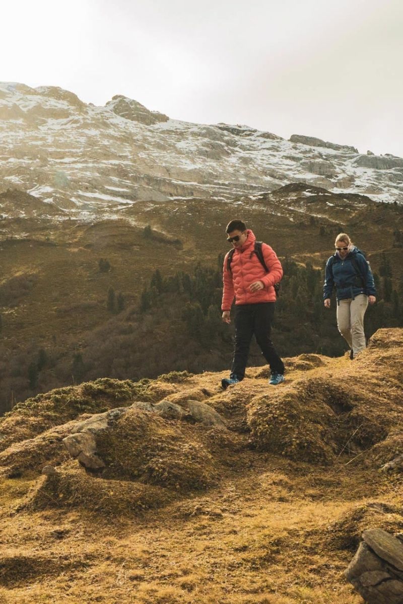 Herbstauszeit_paar_wandern_grillieren_Haslibergoase Paar wandert auf Höhenweg vor verschneiten Bergen im Spätherbst